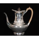 An Edwardian hallmarked silver coffee pot with part fluted decoration below gadroon boarder with