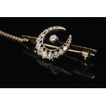 A late Victorian bar brooch with central claw set old cut stone within diamond set crescent border,