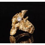 A 1970s abstract yellow metal ring the head formed as curled leaves and highlighted with a single
