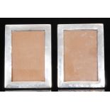 A pair of modern hallmarked silver photograph frames, each with plain rectangular border,