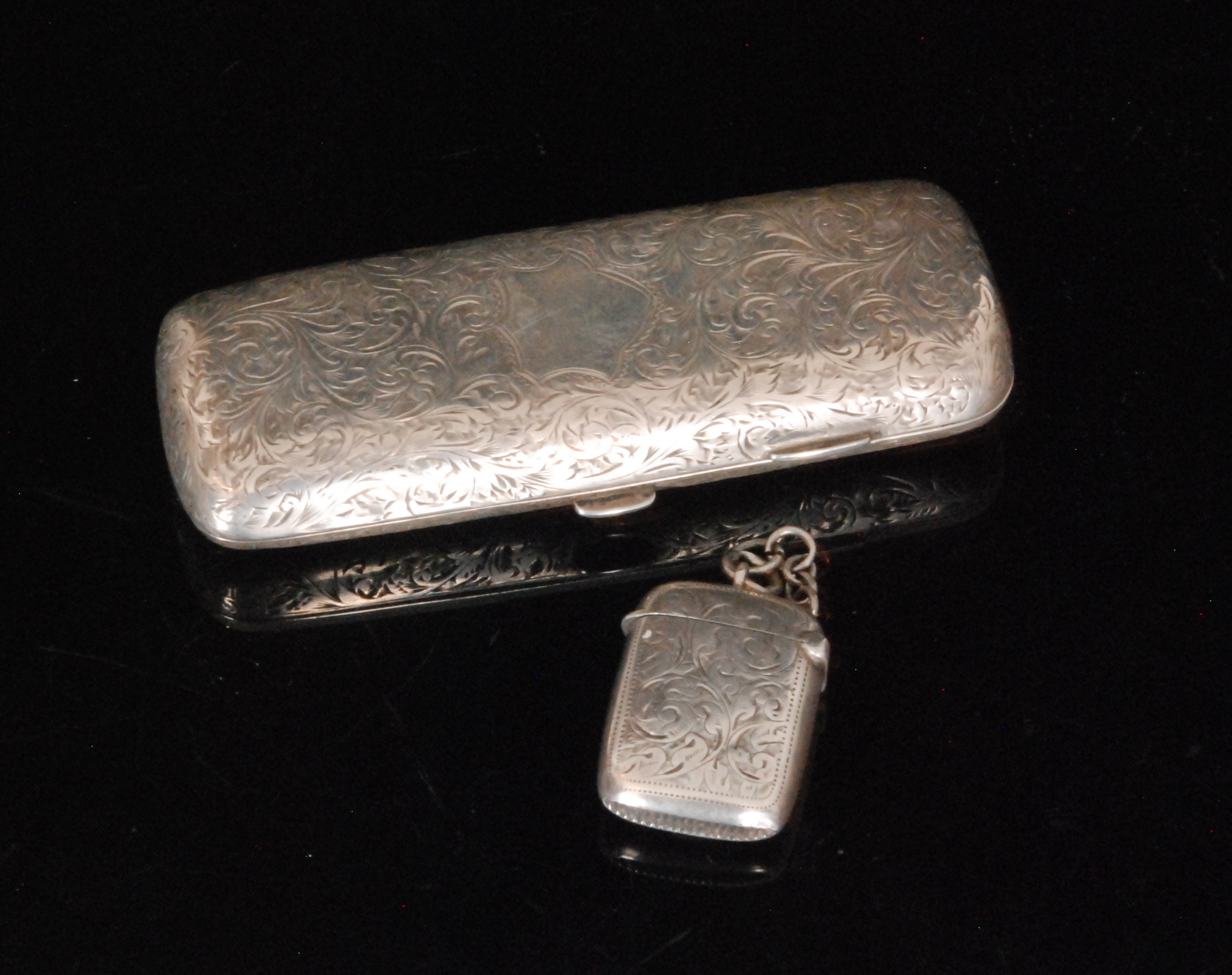 An Edwardian silver cigar case of rounded rectangular form with all over foliate engraved