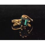 An 18ct single stone green tourmaline ring, square cut claw set stone on a slight twist,