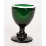 An 18th Century Bristol glass egg cup with shallow conical foot below knopped and baluster stem