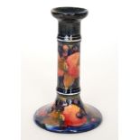 A Moorcroft Pomegranate pattern candlestick of typical form decorated with open and whole fruit and