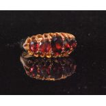 An early 20th Century 9ct rose gold hallmarked graduated five stone claw set garnet boat shaped