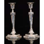 A pair of George V hallmarked silver candlesticks, each with tapered octagonal knopped capital,