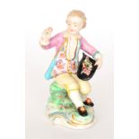 An 18th Century Derby figurine modelled as a young boy sat on a rock,