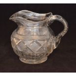 An 18th Century Irish crystal glass water jug of footed ovoid form with flared collar neck having