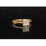 An 18ct diamond ring, four square cut diamonds claw set to knife edged shoulders,