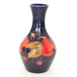 A William Moorcroft Pomegranate pattern bottle vase decorated with tubelined fruit and berries,