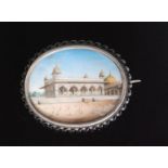 A 19th Century Indian oval miniature watercolour on ivory of an Indian palace with golden domes and