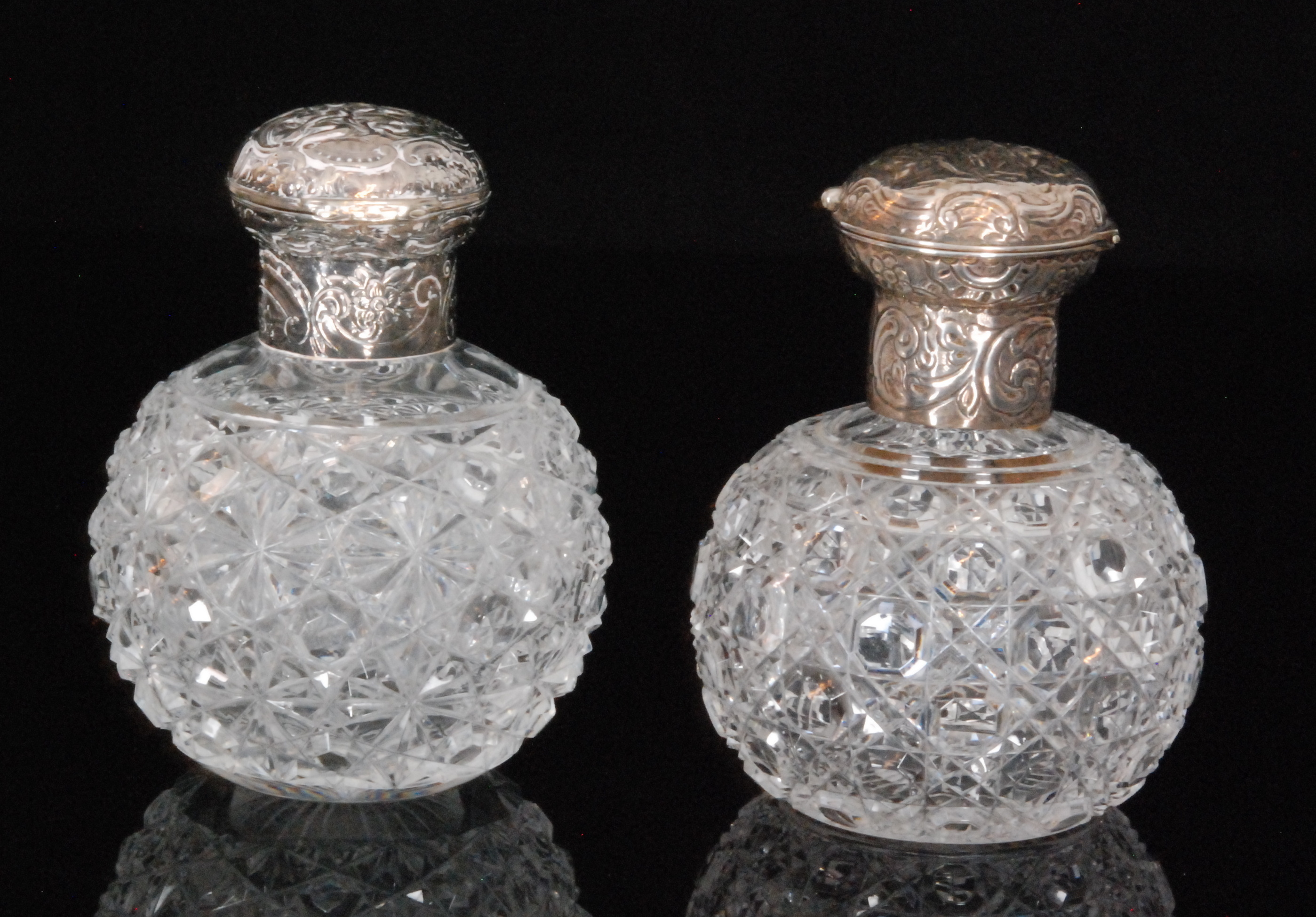 A pair of Victorian silver mounted scent bottles each globular shaped hobnail cut bottle with