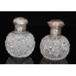 A pair of Victorian silver mounted scent bottles each globular shaped hobnail cut bottle with