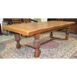 A 17th Century style oak refectory dining table the plank top above a plain frieze on carved legs