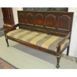 An oak settle with five arch-shaped panels to the back rest,