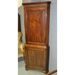 A late Georgian mahogany free-standing corner cupboard with line inlaid detail and raised to