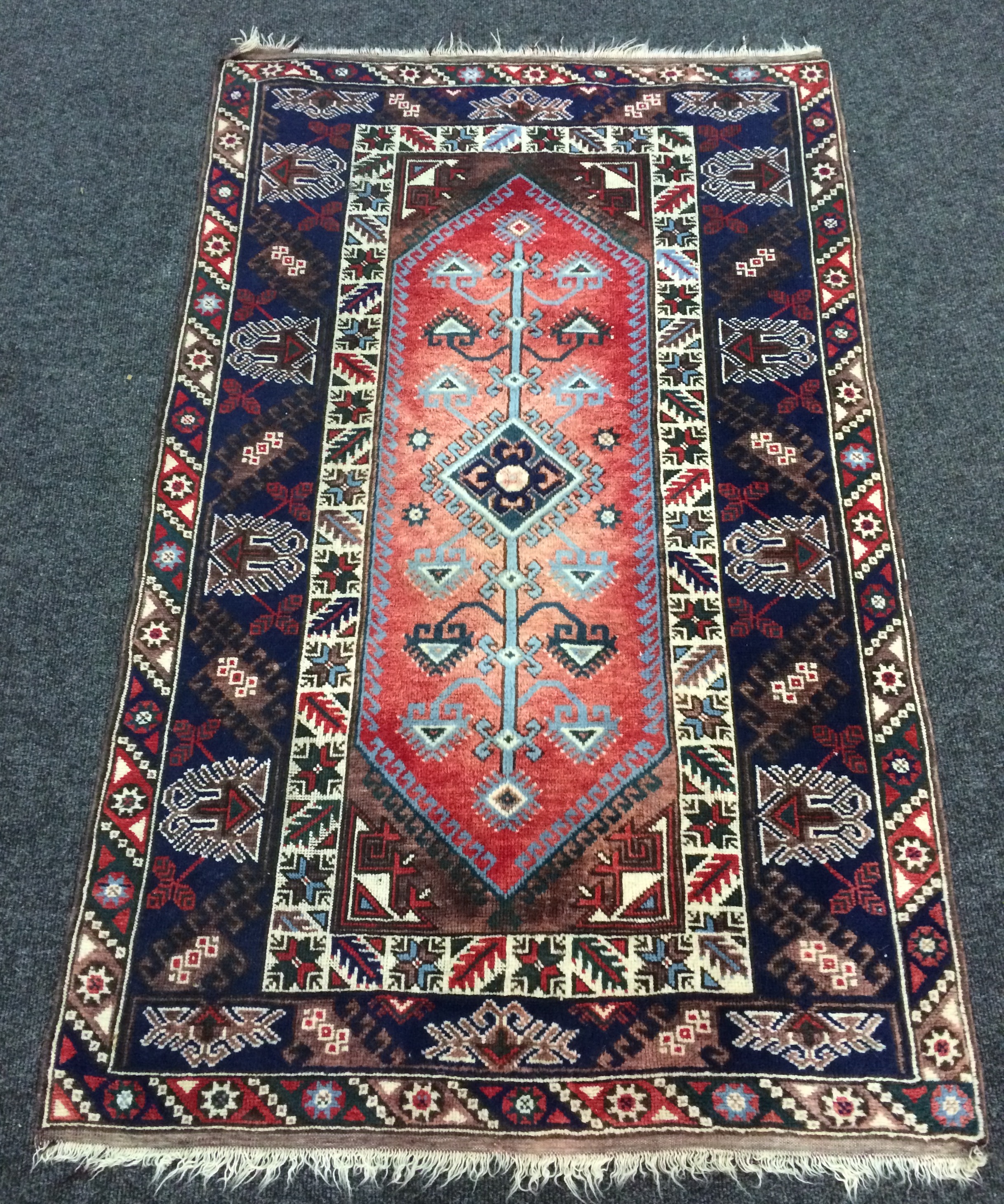 A Kazak style Caucasian rug the centre diamond panel with branched pole design within a hooked and