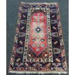 A Kazak style Caucasian rug the centre diamond panel with branched pole design within a hooked and