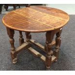 An oak occasional gate-leg table of oval form, raised to a turned stretcher frame,