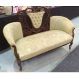 A late 19th to early 20th Century two seat settee with exposed foliate carved frame and cabriole