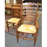 A set of eight 20th Century rush seat beech ladder back dining chairs on turned legs and stretchers