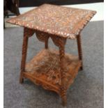 A Victorian carved mahogany square topped two tier occasional table on splayed legs decorated with