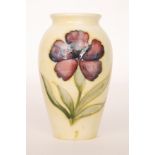 A small Moorcroft vase of tapering form with a roll rim neck,