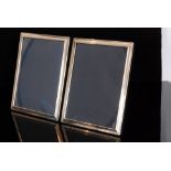 A pair of modern hallmarked silver rectangular easel photograph frames of plain form with ribbon