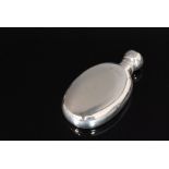 A late Victorian hallmarked silver hip flask of plain ovoid outline and terminating in domed