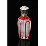 A 19th Century scent bottle red flash clear cut body below octagonal foliate engraved white metal