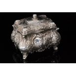 An early 20th Century German silver rectangular casket heavily embossed with foliate scrolls around