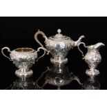 A George V hallmarked silver three piece tea set comprising tea pot, pedestal jug and sugar bowl,