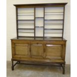 A substantial oak sideboard with twin paneled doors and open married 2 shelf plate rack 58” x 23”