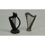 A small unusual silver Harp, with embossed decoration and nine blue topped hat pins as strings,