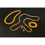 TWO CHINESE AMBER NECKLACES AND A BRACELET. Late 19th-20th century. 26"l.