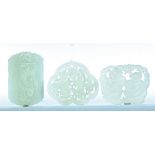 THREE CHINESE JADE CARVINGS. Twentieth century. Two pierce-carved pendants with couples and a