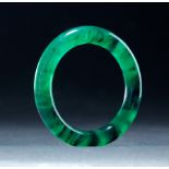 CHINESE JADEITE BANGLE. Nineteenth century. Smooth polished translucent Spanish green with jasper