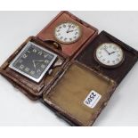 Three various eight day large travelling watches, within folding leather cases (3)