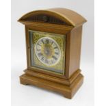 German oak two train mantel clock striking on a gong, the 7" square dial with silvered chapter ring,