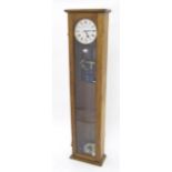 Oak master clock, the 6.5" silvered dial signed Chronomatic within a long glazed case, 50.5" high (