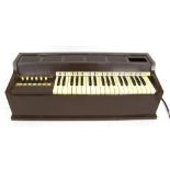 Brown Bakelite electric organ with three octave keyboard and twelve major/minor buttons, 27.5" wide