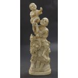 Japanese carved ivory okimono depicting a man holding aloft a boy with a basket of grapes to his