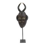 Carved Baule wooden mask, the head mounted by a pair of upright and down-turned horns, upon a cast