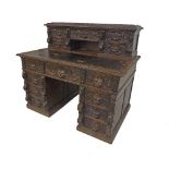 19th century heavily carved oak twin pedestal desk in the Flemish style, the raised back fitted with