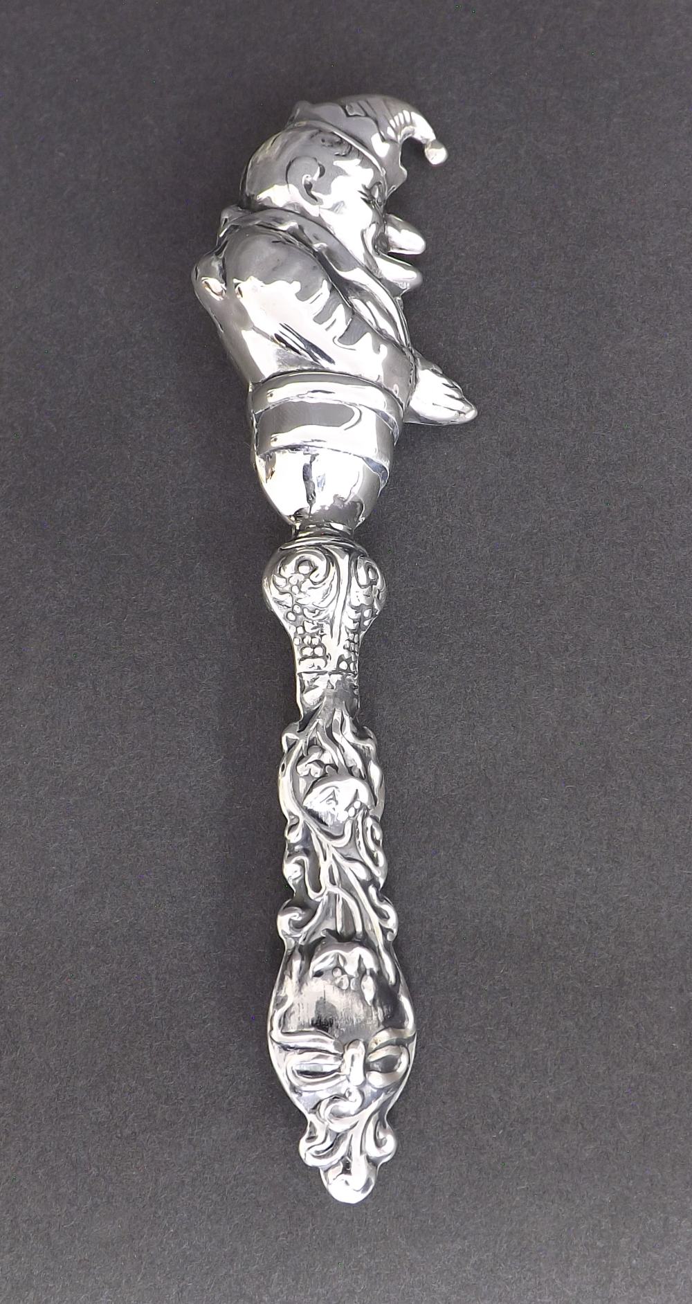 Novelty white metal baby's rattle in the form of Mr Punch, 6" long