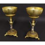 Pair of decorative silvered and gilt metal stands, the stems modelled with winged sphinx upon