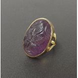 Oval carved amethyst dress ring, carved in relief with a flowerhead in a gold rubover setting and