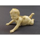 Carved ivory figure of a crawling young child, 2" high, 4" long