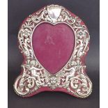 Silver heart shaped easel picture frame, embossed with cherubs and scrolled foliage, stamped