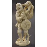 Japanese ivory okimono modelled as a performer with a monkey upon his shoulder, inset signed red